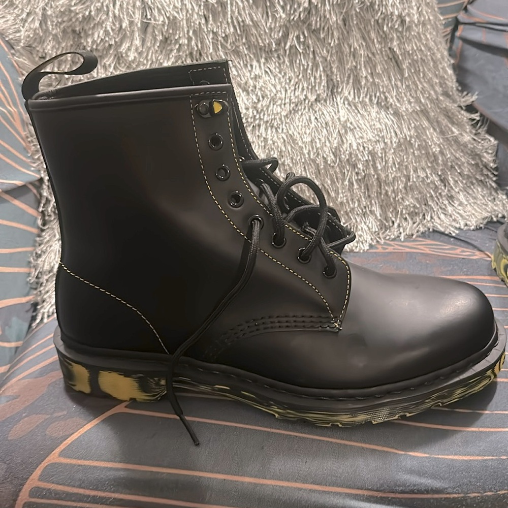 Black Dr. Martens with yellow details on the sole.